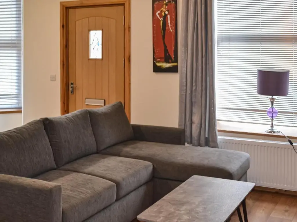 a living room with a couch and a table at Harbour Apartment in Nairn