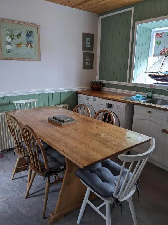 a kitchen with a wooden table and chairs at Craigmile Cottage in Fraserburgh