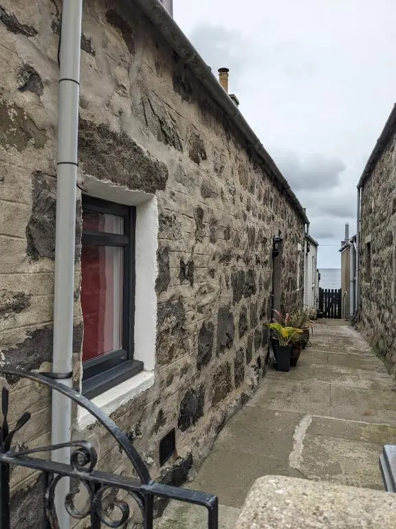 a stone building with a window on a street at Craigmile Cottage in Fraserburgh