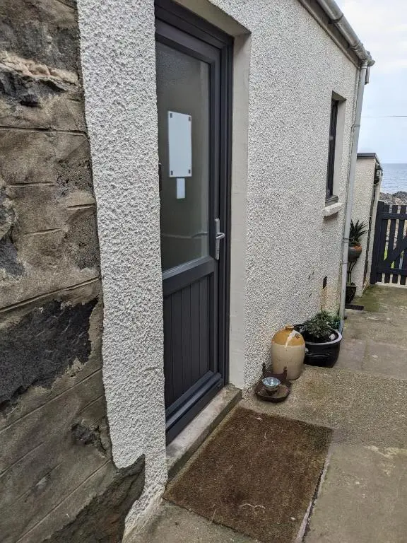 a door to a house with a sign on it at Craigmile Cottage in Fraserburgh