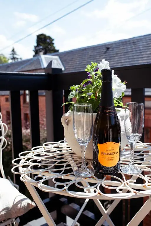 a bottle of wine sitting on a table with two glasses at The River Nest in Dalneigh