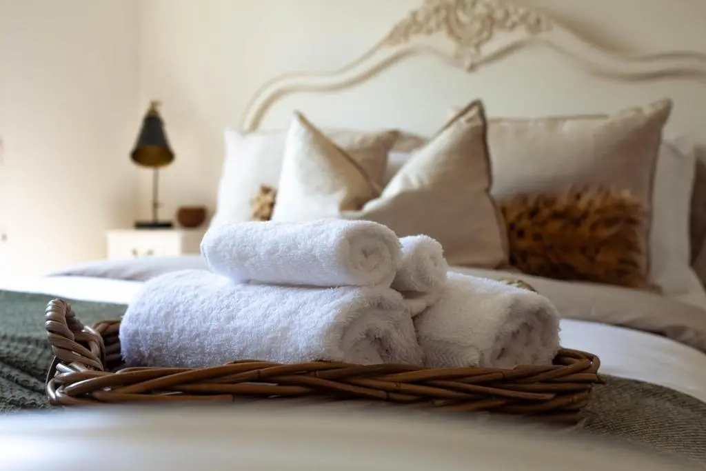 a pile of towels in a basket on a bed at The River Nest in Dalneigh