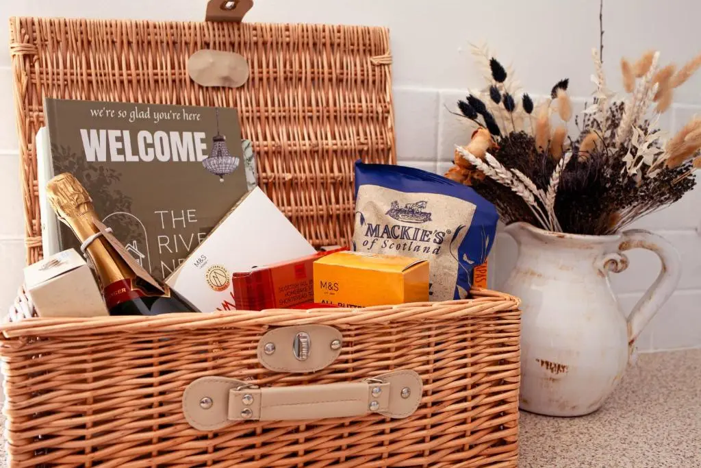 a basket with a bottle of wine and a book at The River Nest in Dalneigh