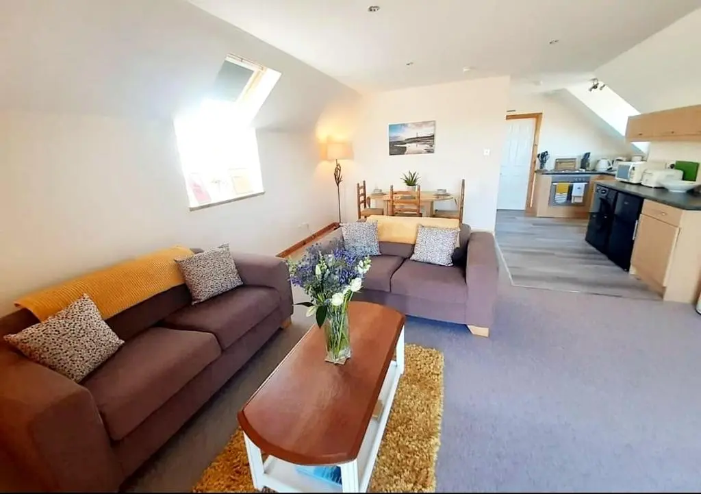a living room with two couches and a table at Balormie View in Lossiemouth