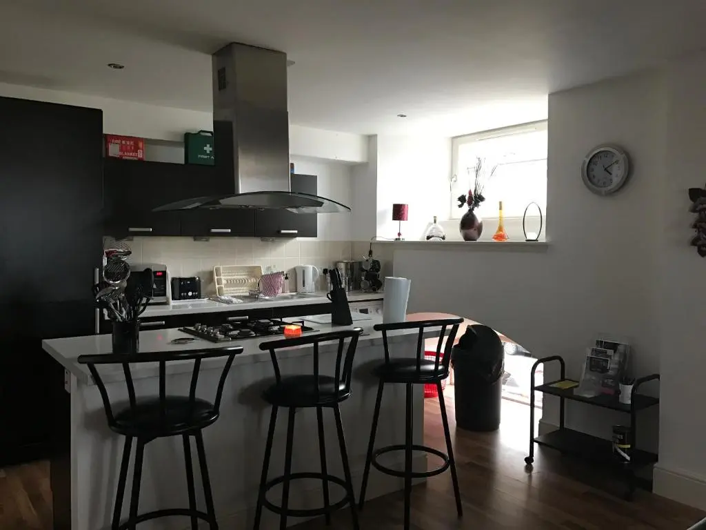 a kitchen with three bar stools and a counter top at Scardroy Homes Inverness - Central 2 Bedroom with Parking WiFi Smart TVs Sleeps up to 6 in Inverness