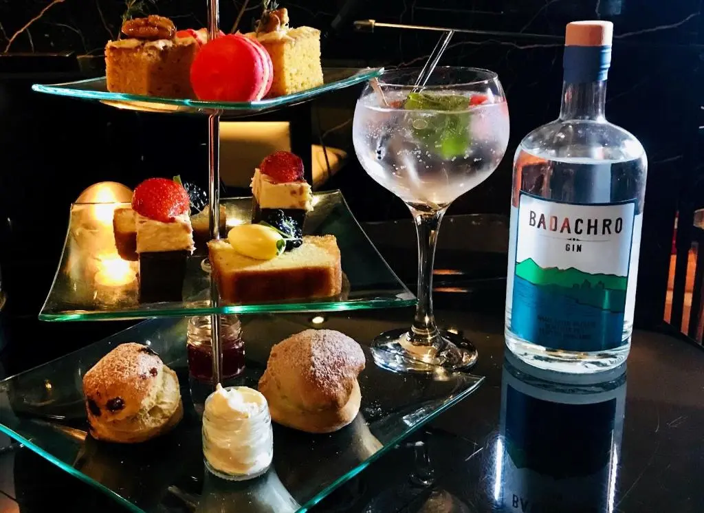 a bottle of wine next to a plate of desserts at The Glenmoriston Townhouse Hotel in Inverness