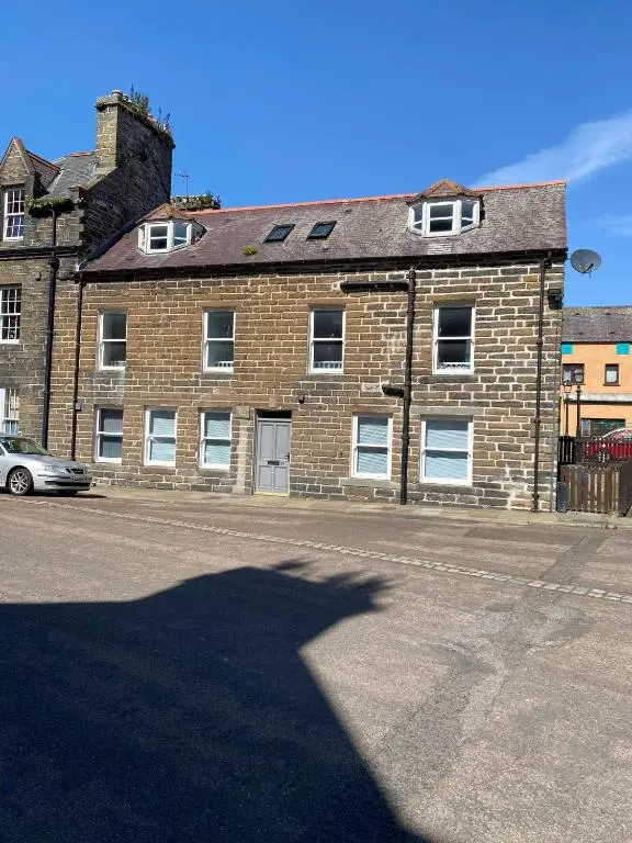 a shadow of a building on the side of a street at 3 Bedroom Townhouse on NC500, Wick, Highland in Wick