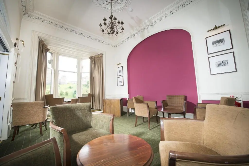 a room with chairs and a table and a purple wall at Columba Hotel Inverness by Compass Hospitality in Inverness