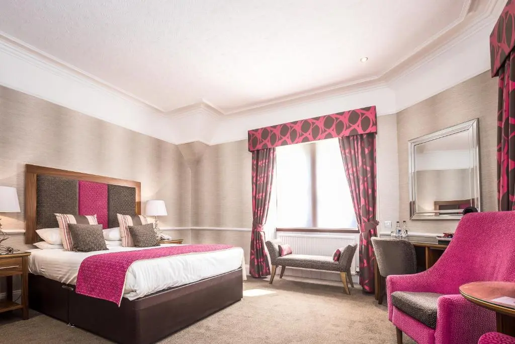 a hotel room with a bed and a desk at Craigmonie Hotel Inverness by Compass Hospitality in Inverness