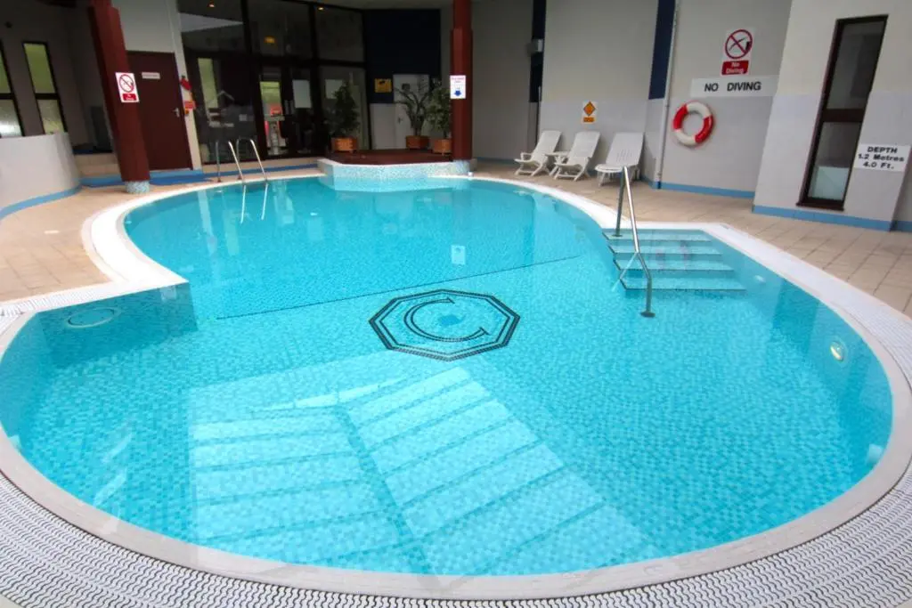 a large blue swimming pool in a building at Craigmonie Hotel Inverness by Compass Hospitality in Inverness
