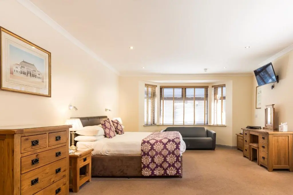 a bedroom with a bed and a desk and a television at Craigmonie Hotel Inverness by Compass Hospitality in Inverness