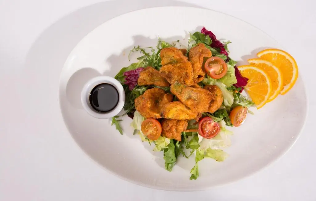 a plate of food with a salad and fried calamari at The Royal Highland Hotel in Inverness