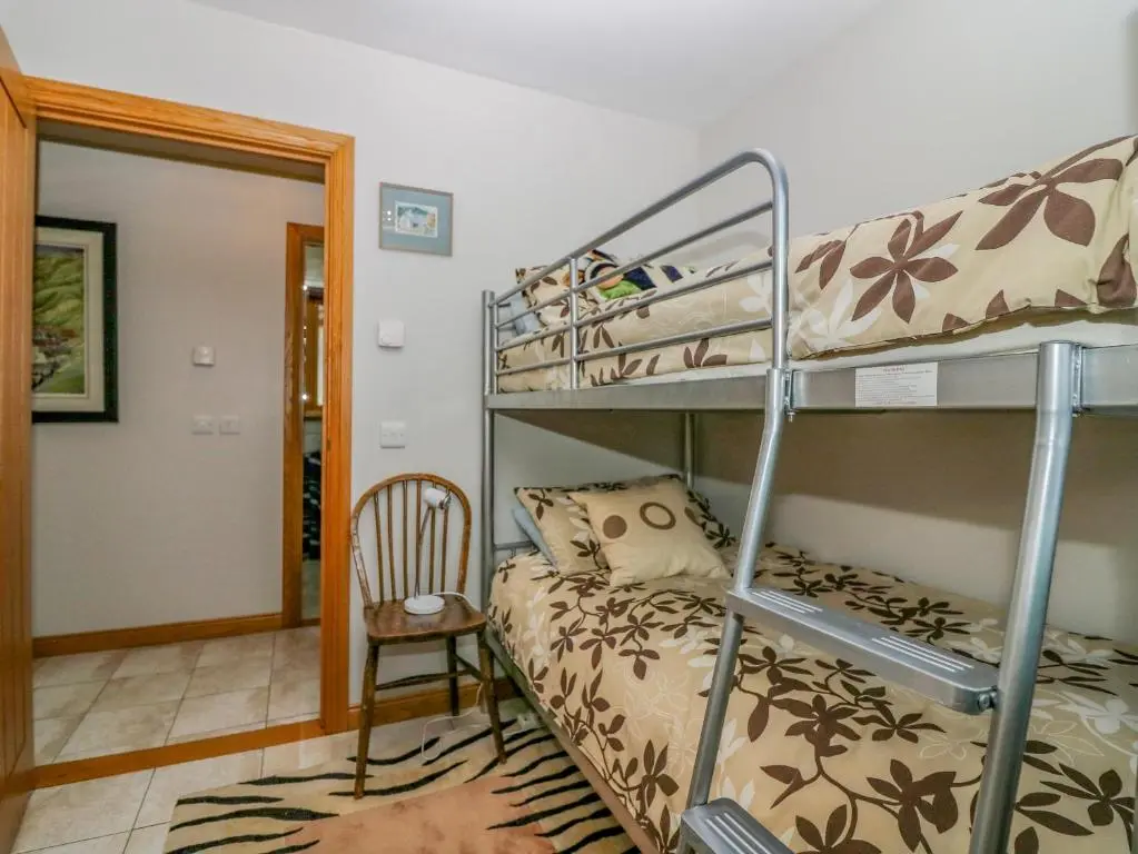 a bedroom with a bunk bed and a chair at Otakaro in Tomintoul