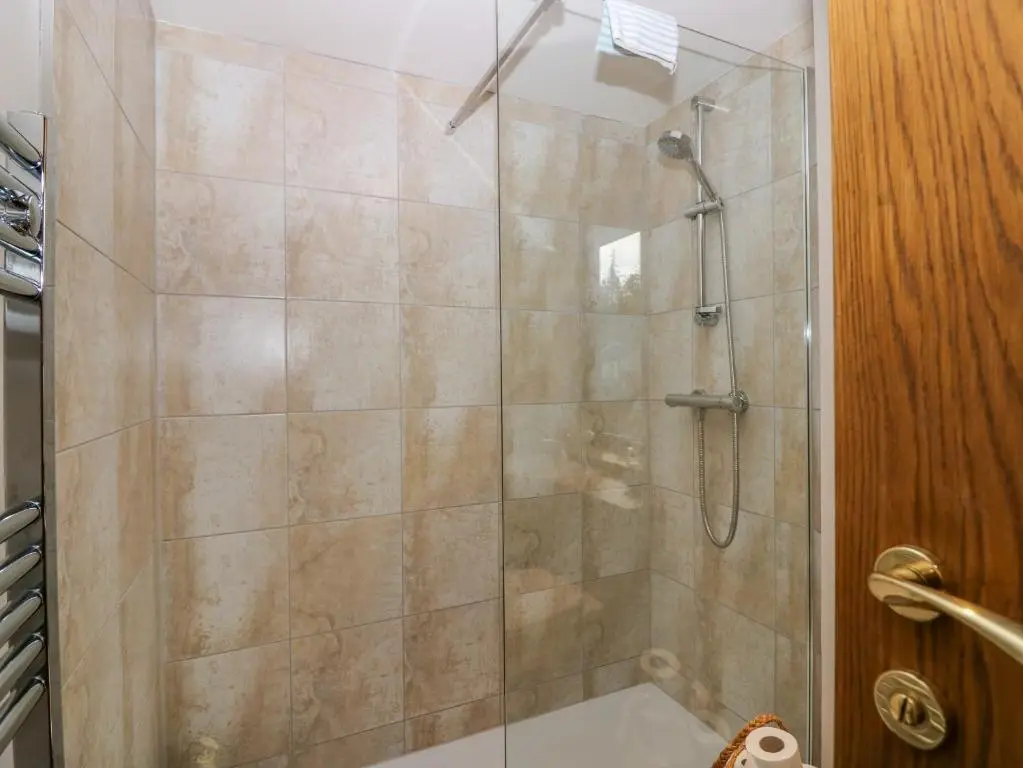 a shower with a glass door in a bathroom at Otakaro in Tomintoul