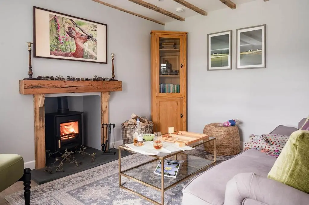 a living room with a fireplace and a couch at Gleann Cottage - Seasgair Lodges in Kincraig