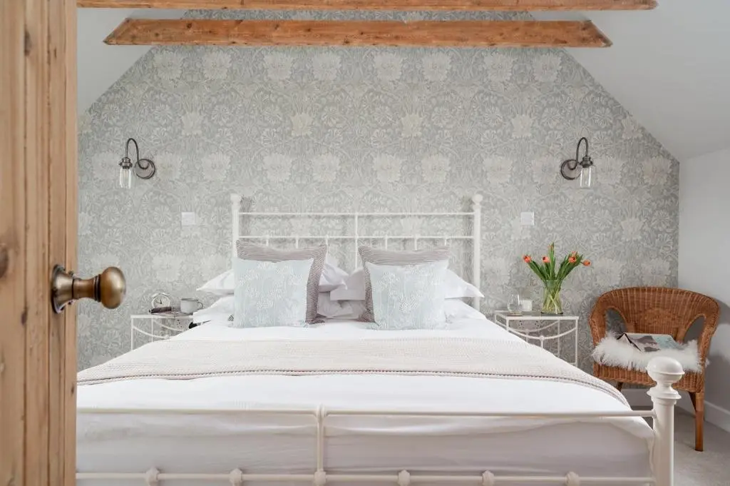 a bedroom with a white bed and a chair at Beinn Cottage - Seasgair Lodges in Kincraig
