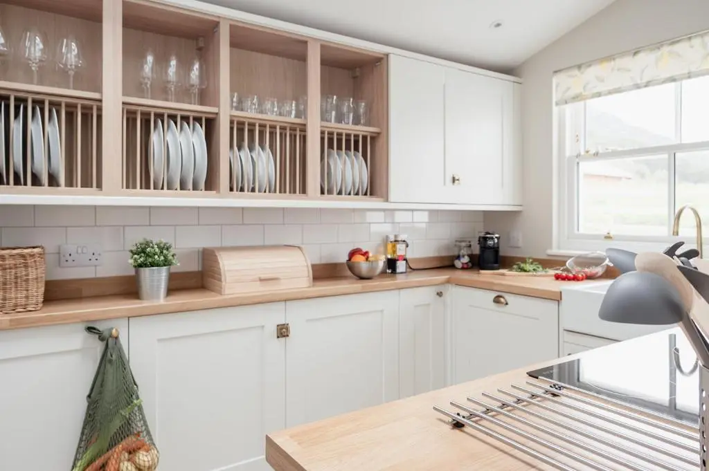a kitchen with white cabinets and a counter top at Beinn Cottage - Seasgair Lodges in Kincraig