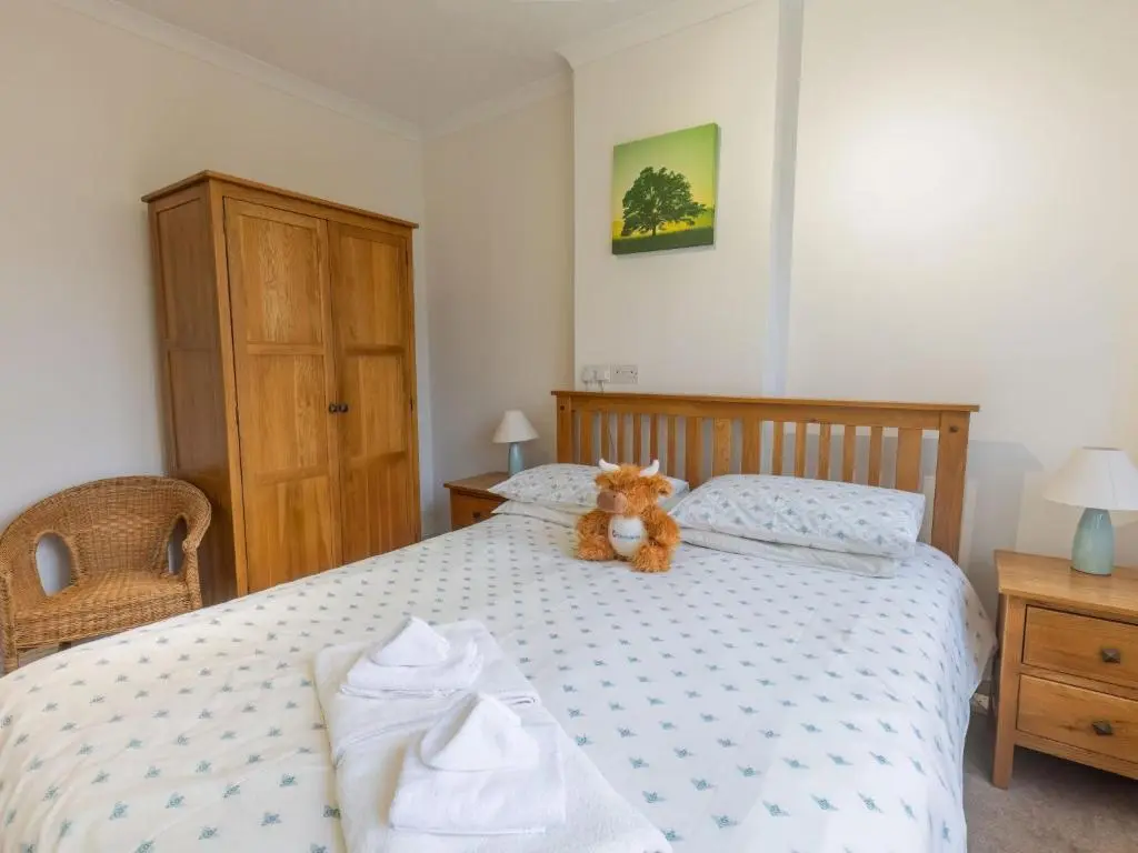 a teddy bear sitting on a bed in a bedroom at Holiday Home Beech by Interhome in Inverness