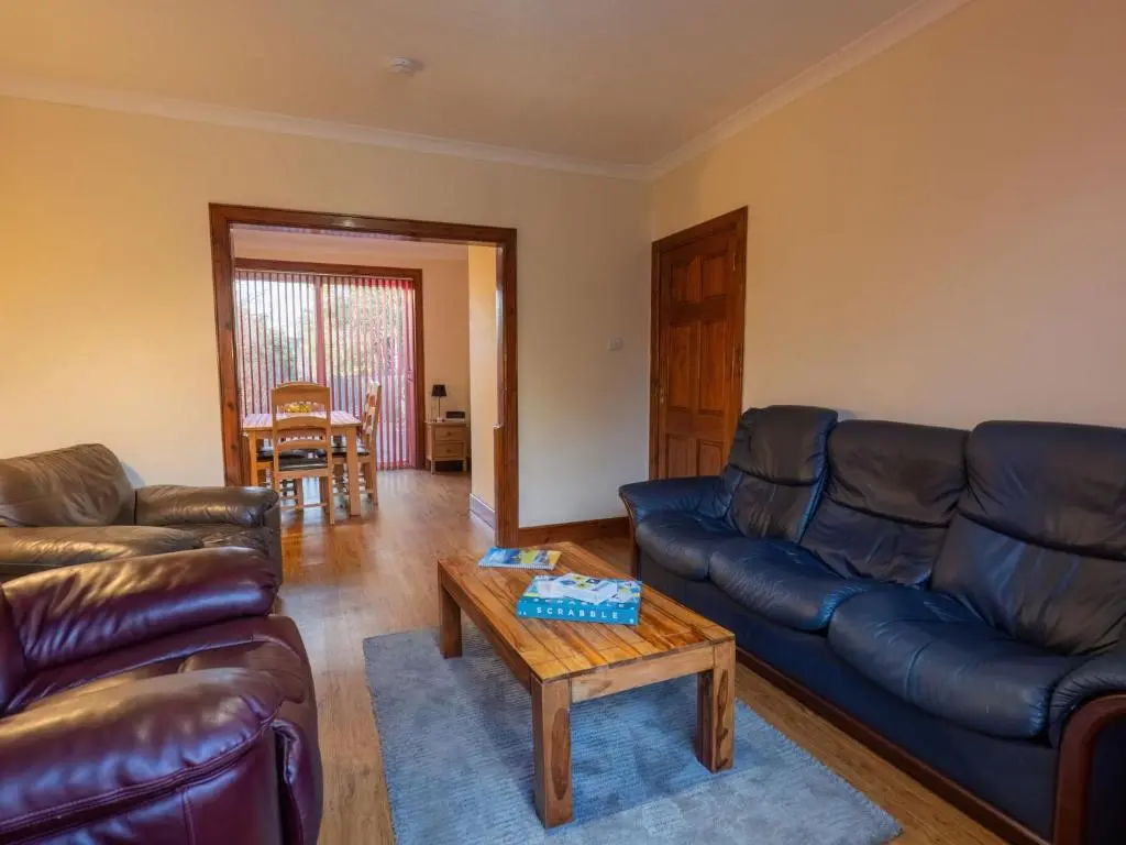 a living room with leather couches and a coffee table at Holiday Home Beech by Interhome in Inverness