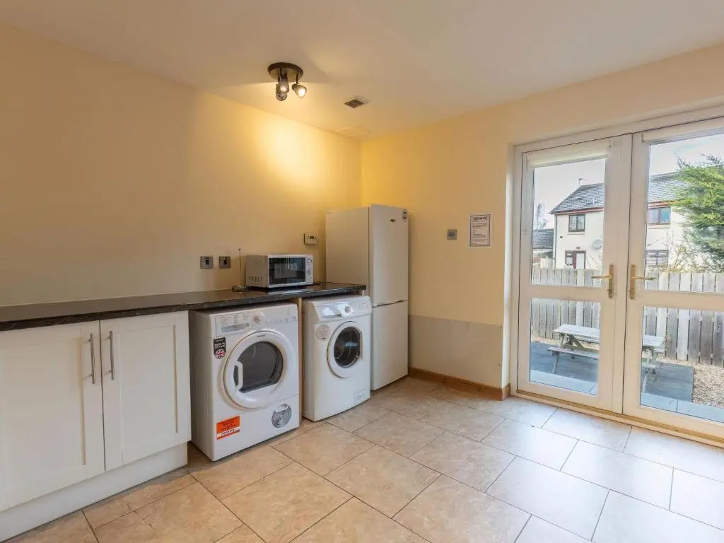 a kitchen with a washer and dryer in a room at Holiday Home Ardness Place by Interhome in Inverness