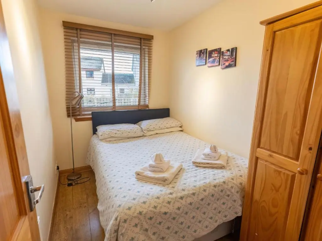 a small bedroom with a bed with towels on it at Holiday Home Ardness Place by Interhome in Inverness
