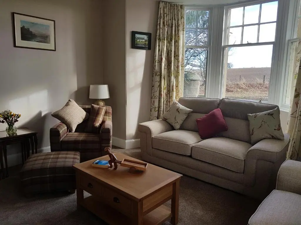 a living room with a couch and a table at Dalvey East Lodge in Forres