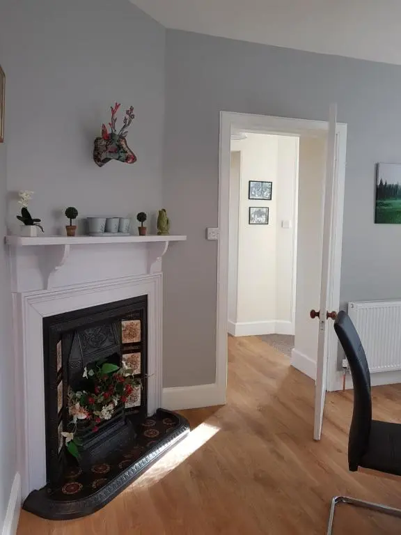 a living room with a fire place in the middle at Dalvey East Lodge in Forres