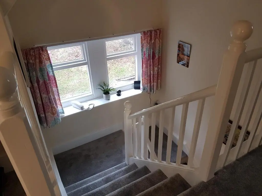 a stairway with two windows and a stair case at Dalvey East Lodge in Forres