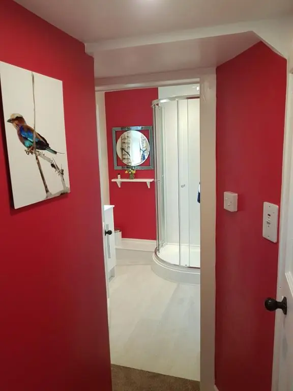 a room with red walls and a bird picture on the wall at Dalvey East Lodge in Forres