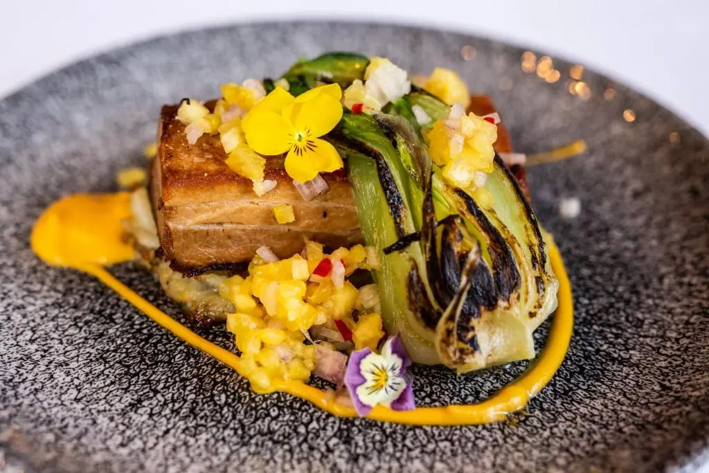 a plate with a piece of food with flowers on it at Dalmunzie Castle Hotel in Glenshee