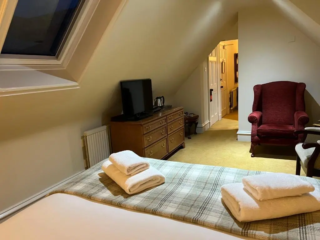 a bedroom with a bed with two towels on it at Dalmunzie Castle Hotel in Glenshee