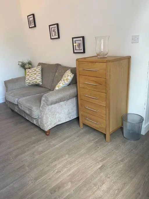 a living room with a couch and a dresser at Aberlour Apartment 92 B in Aberlour