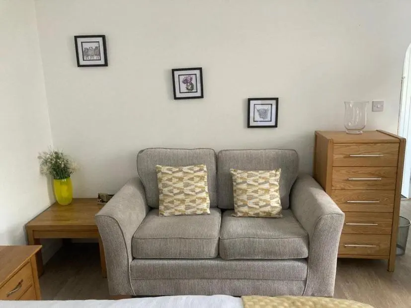a living room with a couch with two pillows at Aberlour Apartment 92 B in Aberlour