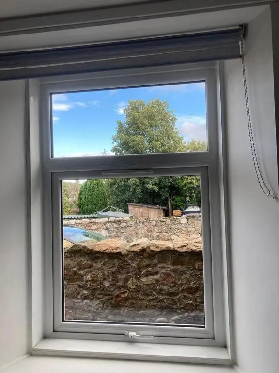 a window in a room with a stone wall at Aberlour Apartment 92 B in Aberlour