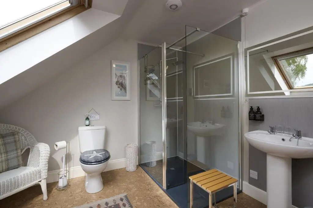 a bathroom with a shower and a toilet and a sink at Dunaincroy Farmhouse in Inverness