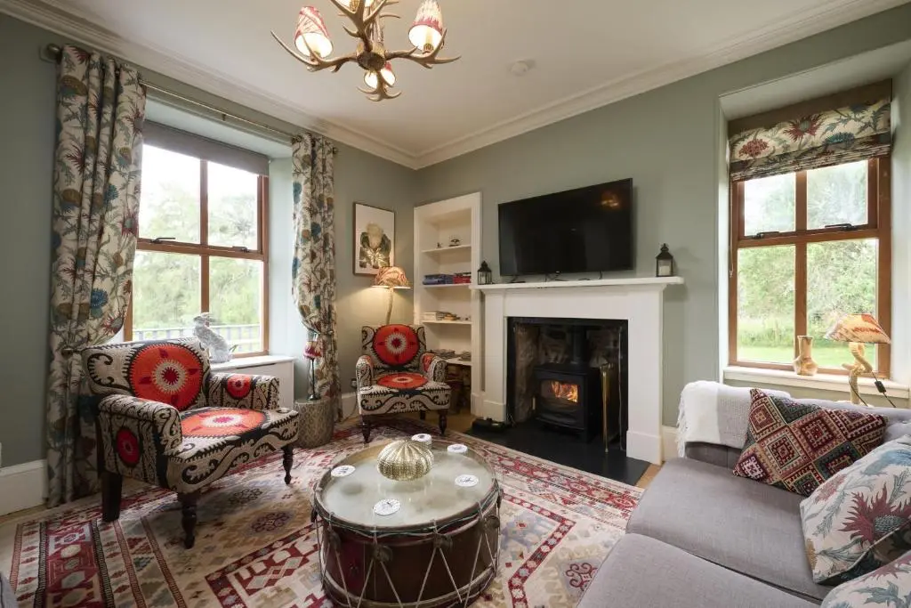 a living room with a couch and a fireplace at Dunaincroy Farmhouse in Inverness
