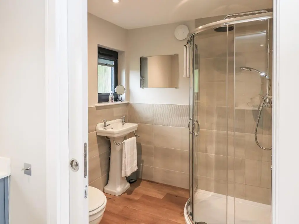 a bathroom with a shower and a sink and a toilet at Wee Smithy in Munlochy
