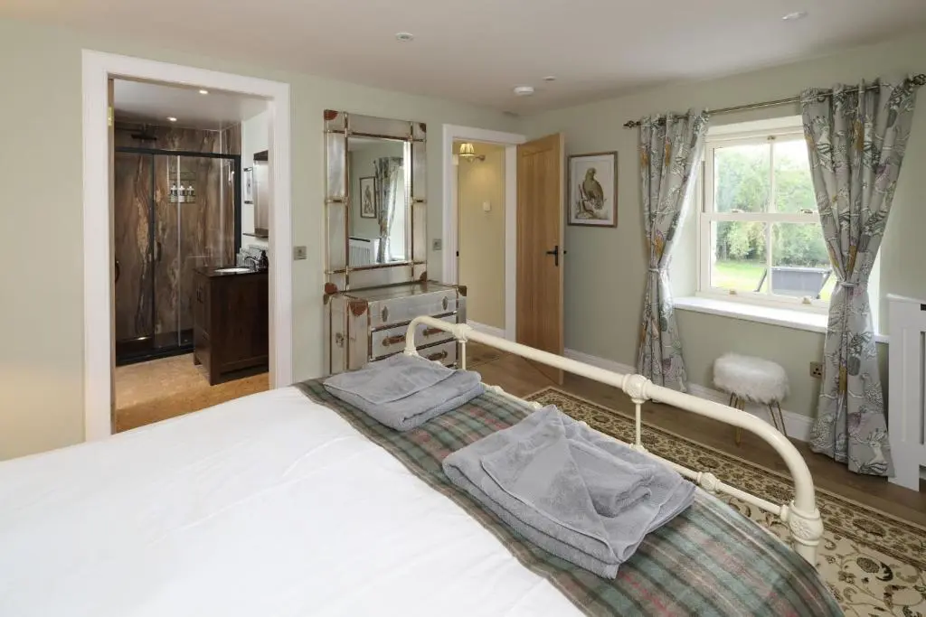 a bedroom with a white bed and a window at Middleton Farmhouse in Inverness