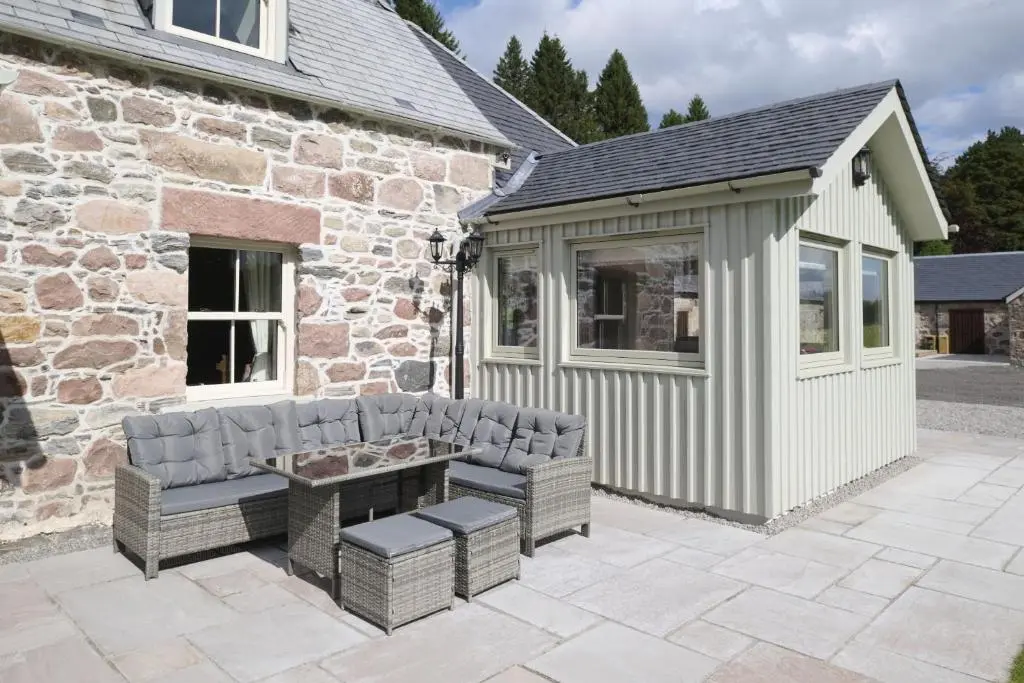 a patio with a bench and a building at Middleton Farmhouse in Inverness