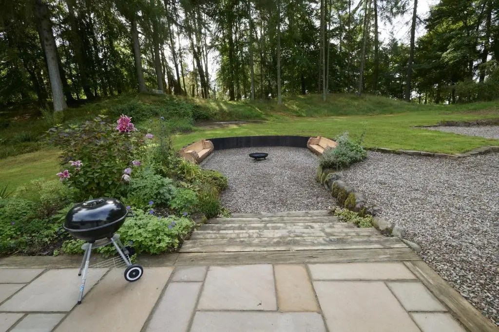 a garden with a grill in the middle of a yard at Upper Dunain in Inverness