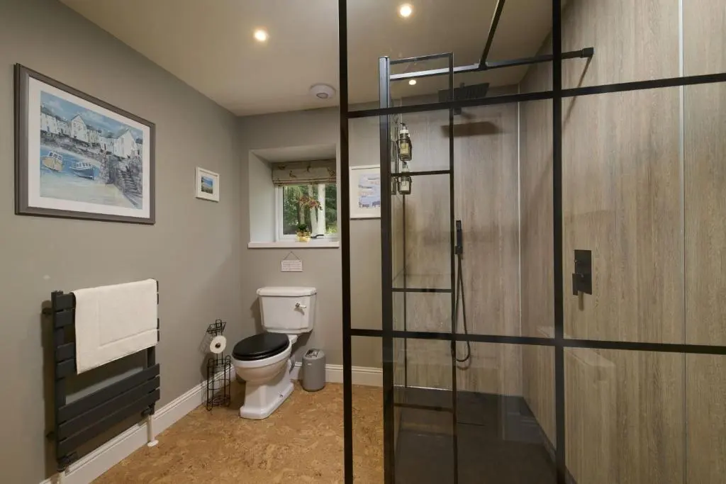 a bathroom with a toilet and a glass shower stall at Upper Dunain in Inverness