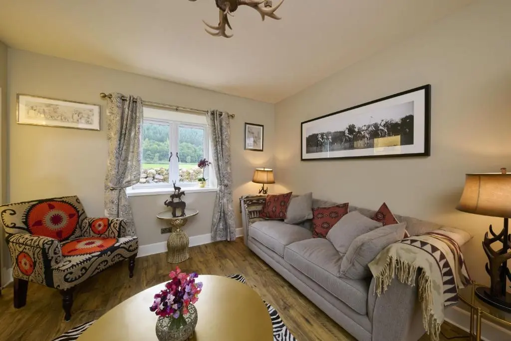 a living room with a couch and a table at Upper Dunain in Inverness
