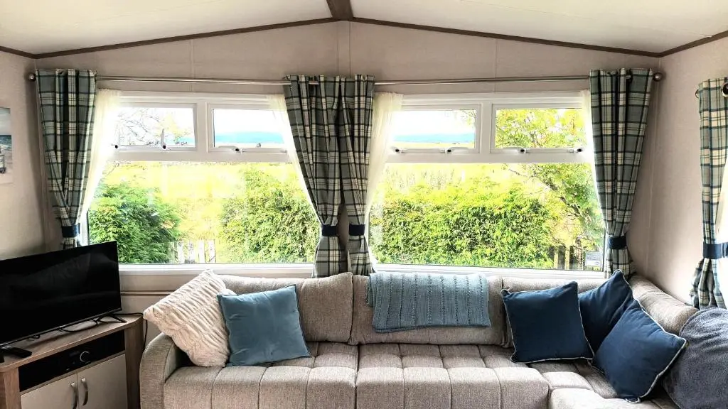 a living room with a couch and two windows at Suki - up to 6 berth cabin, new. in Tain