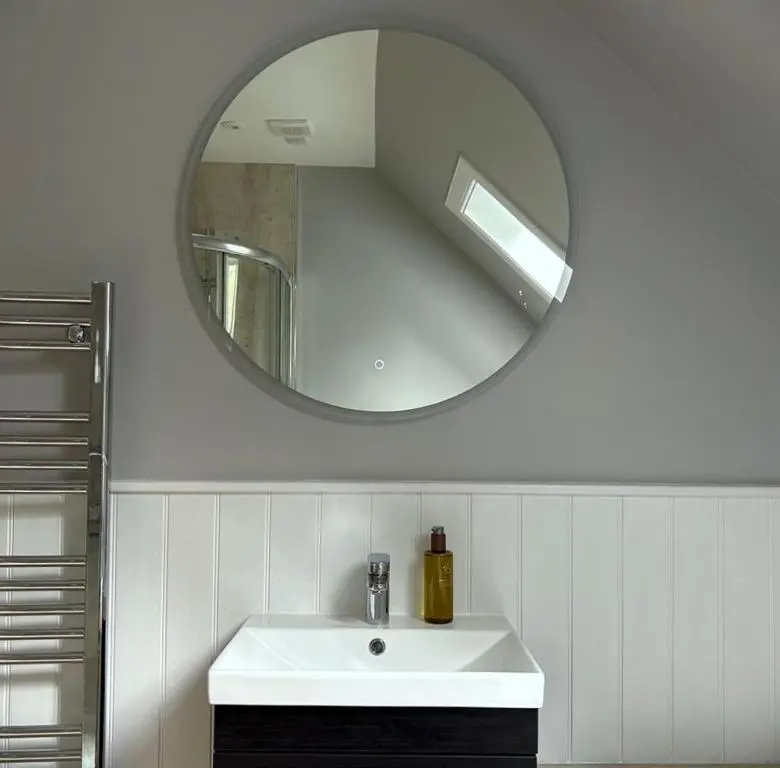 a white bathroom with a sink and a mirror at The Fiddich Luxury Home in Craigellachie in Craigellachie