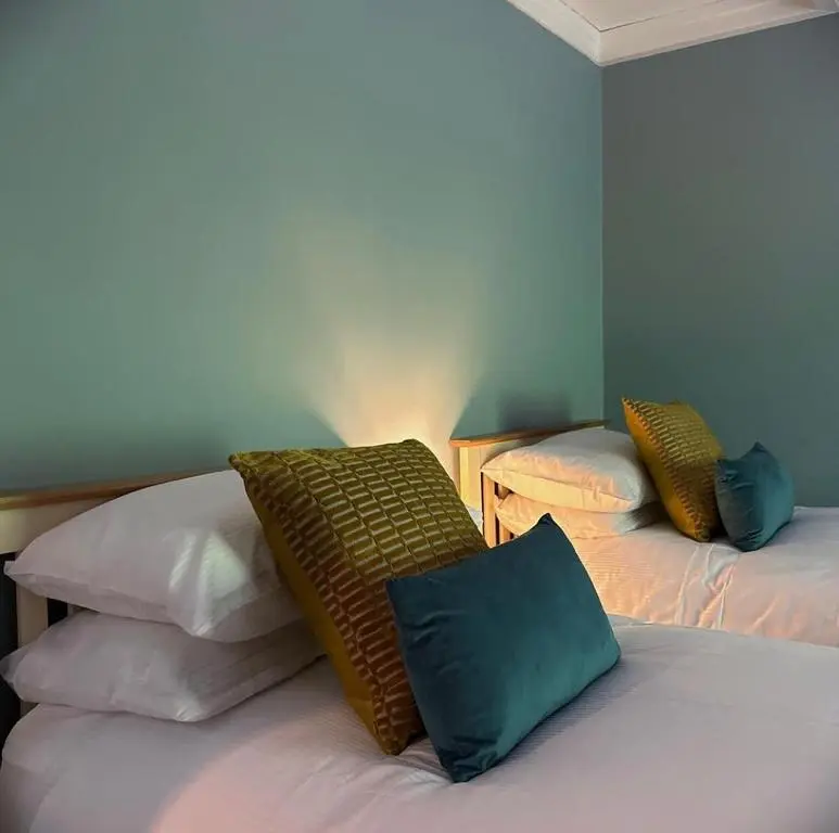 a bedroom with two beds with pillows on them at The Fiddich Luxury Home in Craigellachie in Craigellachie