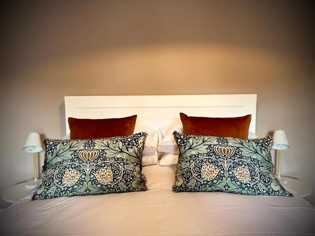 a bedroom with a bed with two pillows at The Fiddich Luxury Home in Craigellachie in Craigellachie