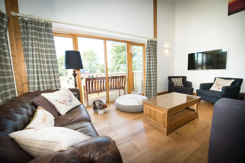 a living room with a leather couch and a coffee table at Atlas in Nairn