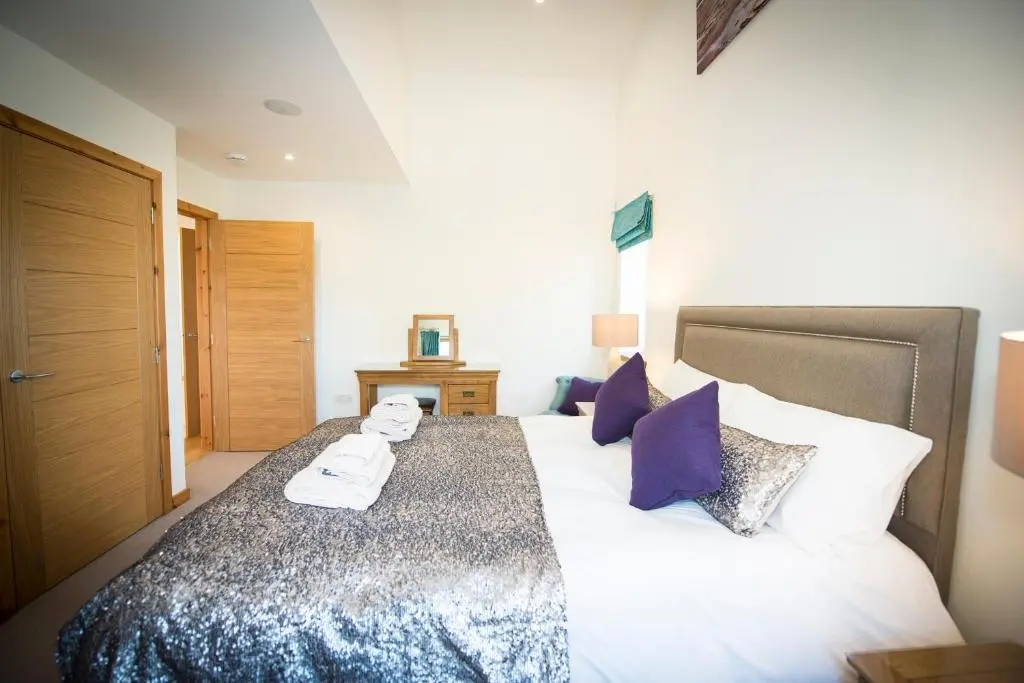 a bedroom with a large bed with towels on it at Atlas in Nairn