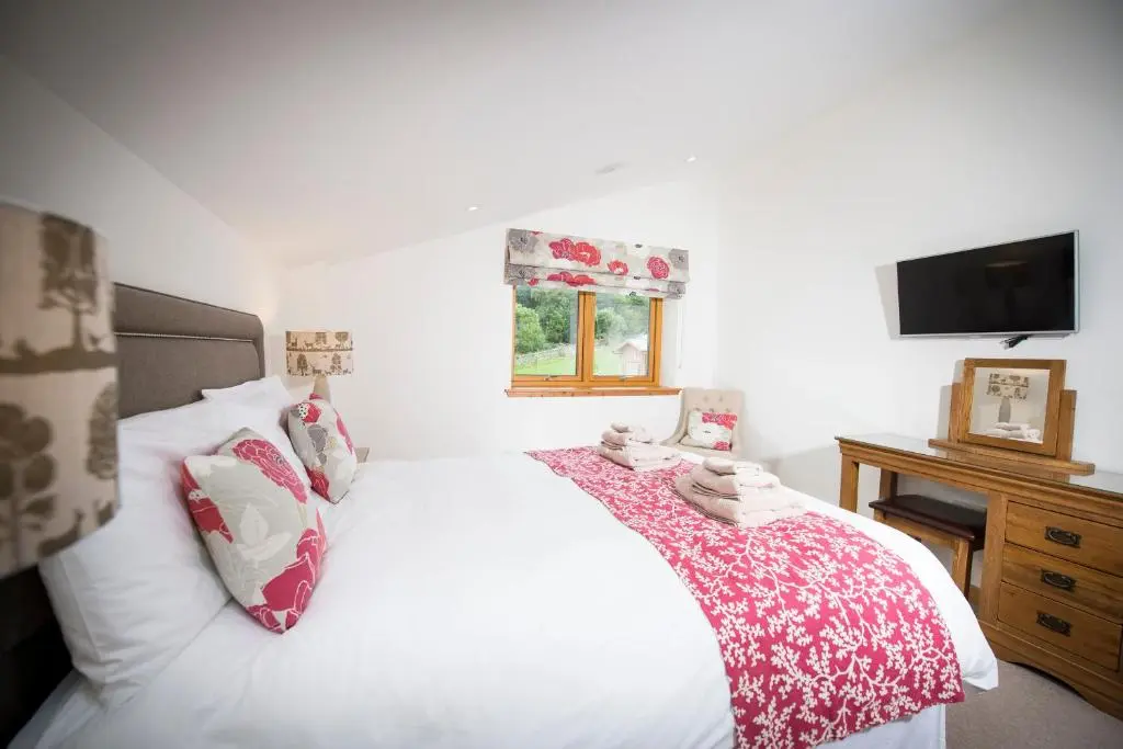 a bedroom with a white bed and a television at Aurae in Nairn