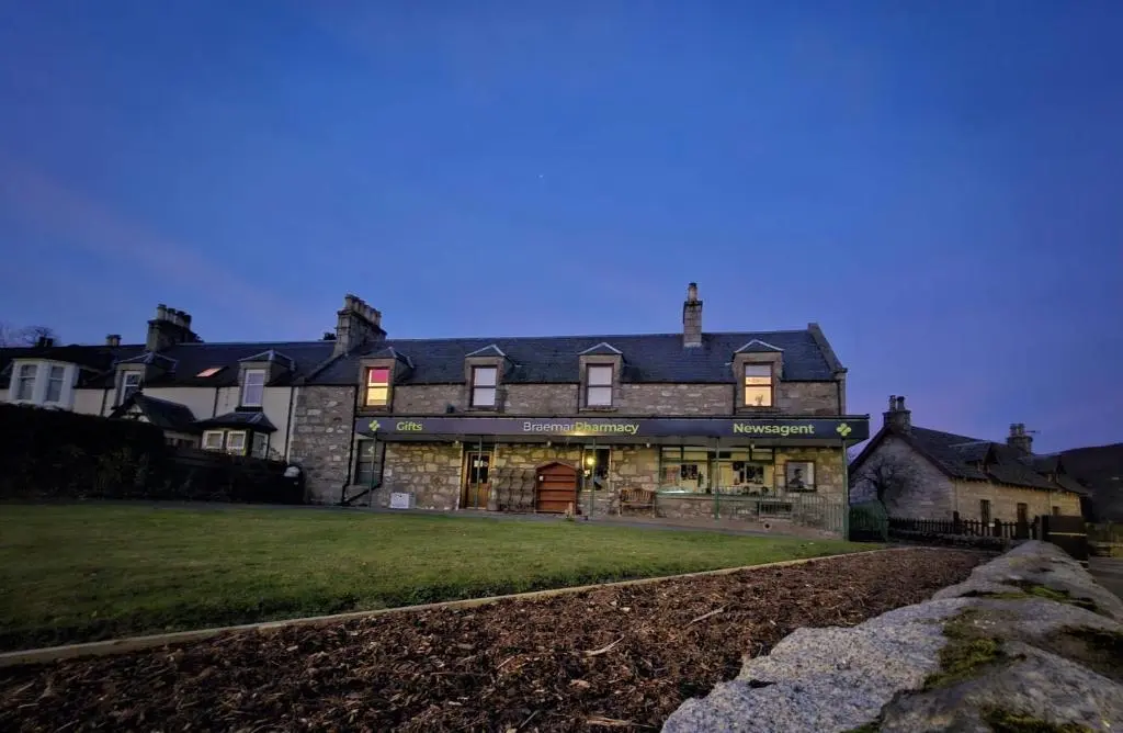 a large stone building with lights on at Bruachdryne Braemar Accommodation in Braemar